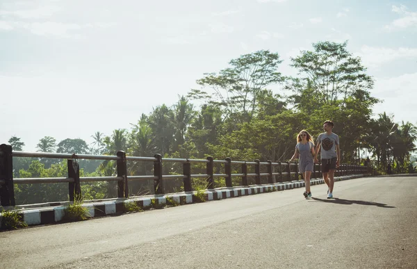 Hipster pár chůze na mostě v tropech — Stock fotografie