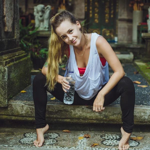 Retrato de una joven bebiendo agua. Chica con estilo contra nat — Foto de Stock