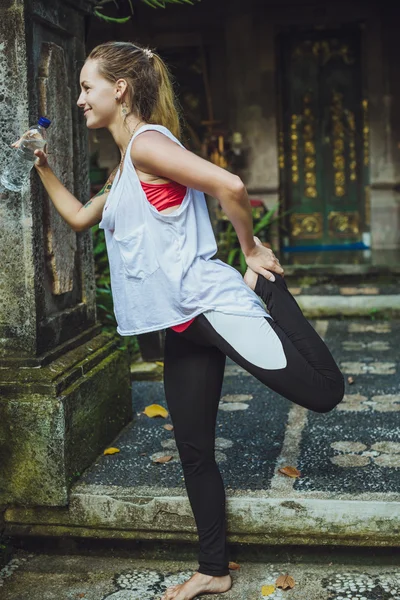 Young fitness woman stretching after workout in the park — Stock Photo, Image