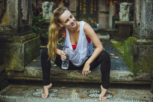 Retrato de una joven bebiendo agua. Chica con estilo contra nat — Foto de Stock