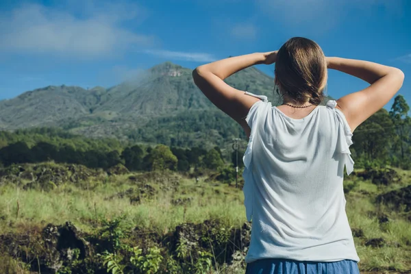 Mladá žena hledá na sopka Batur a Agung mountain view na — Stock fotografie