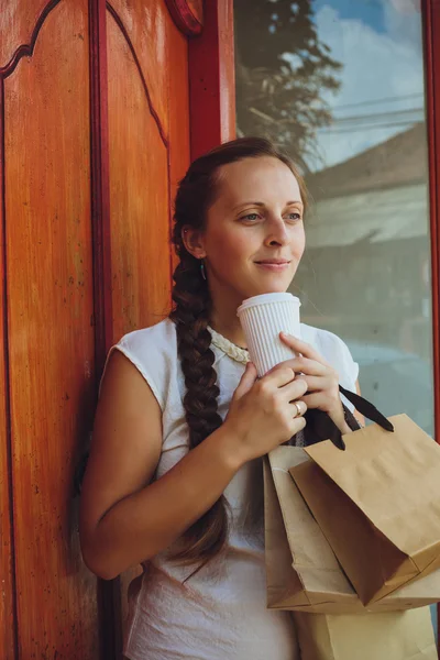 Молодая современная женщина в магазине с пакетами через плечо с — стоковое фото