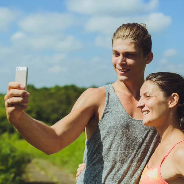 Young couple taking a selfie with a smartphone before working ou — Stock Photo, Image