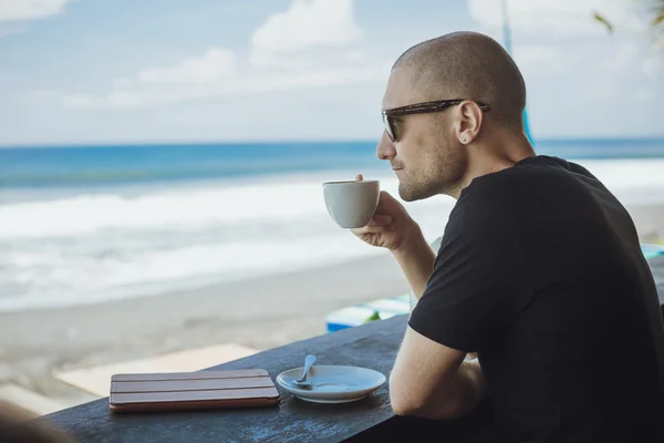 Jovem com sua xícara de café da manhã olhando para o oceano vi — Fotografia de Stock