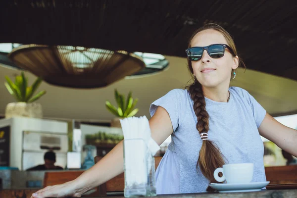Jonge vrouw drinken koffie in de ochtend op restaurant in de buurt van t — Stockfoto