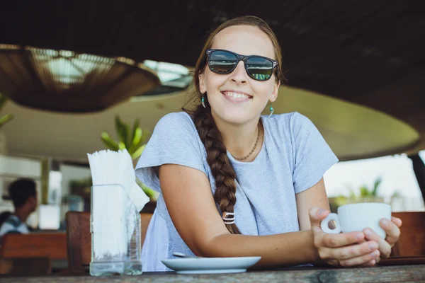 Jonge vrouw drinken koffie in de ochtend op restaurant in de buurt van t — Stockfoto