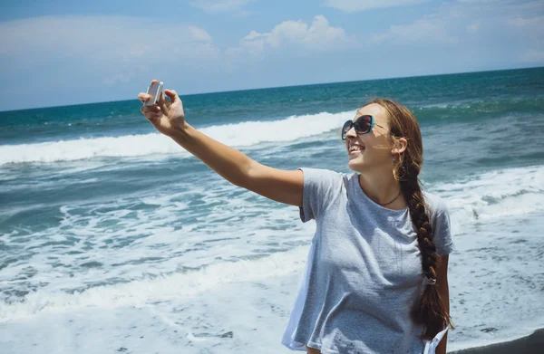 Mooie jonge vrouw het nemen van een selfie op het strand — Stockfoto