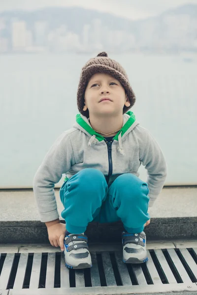 5 anno-vecchio ragazzo in un divertente cappello è seduto e riposo su il passo — Foto Stock