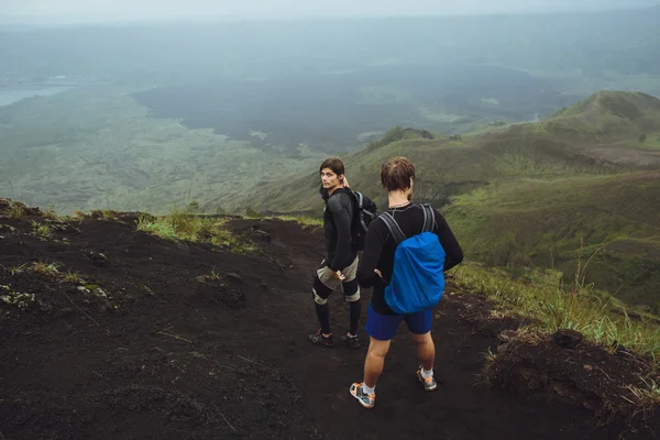 3 Men walk along the hill with backpacks and with white clouds a — Stock Photo, Image