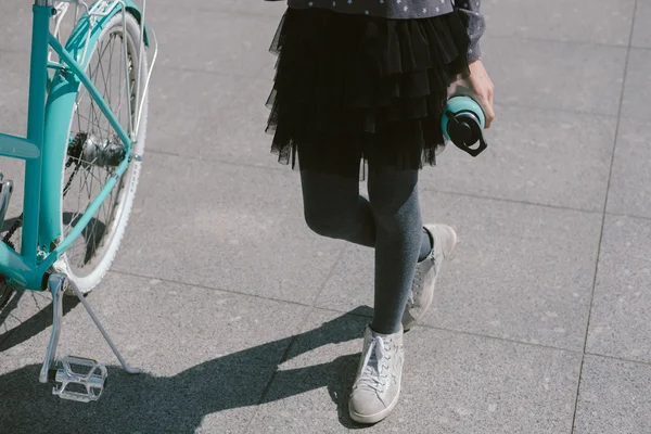Tienermeisje rusten in een straat met een fiets-drinkwater — Stockfoto