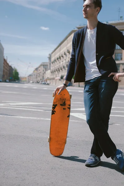 Ο άνθρωπος της μόδας σε ένα skateboard στην πόλη — Φωτογραφία Αρχείου