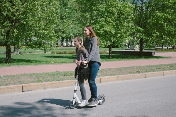 Matka i córka jazdy na skuter w mieście — Zdjęcie stockowe