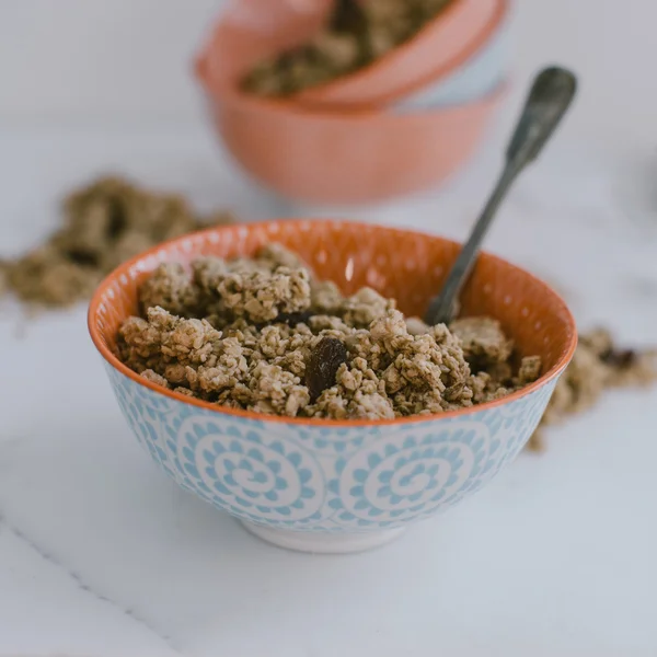 Muesli em uma tigela em um fundo de madeira marrom — Fotografia de Stock