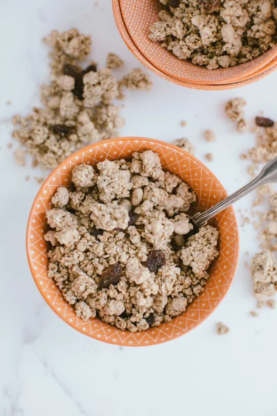 Muesli em uma tigela em um fundo de madeira marrom — Fotografia de Stock