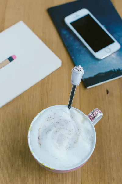 Slimme telefoon met notitieboekje en kopje sterke koffie op houten bac — Stockfoto