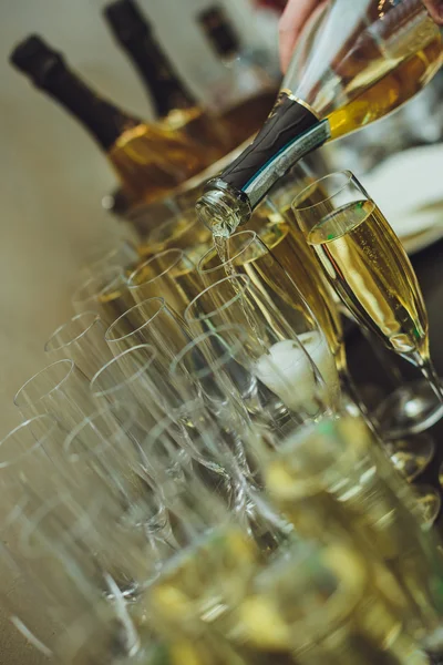 Elegantes copas con champán de pie en una fila en la mesa de servir — Foto de Stock