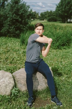 Erkek koşucu germe egzersiz yaparak sabah wor için hazırlanıyor