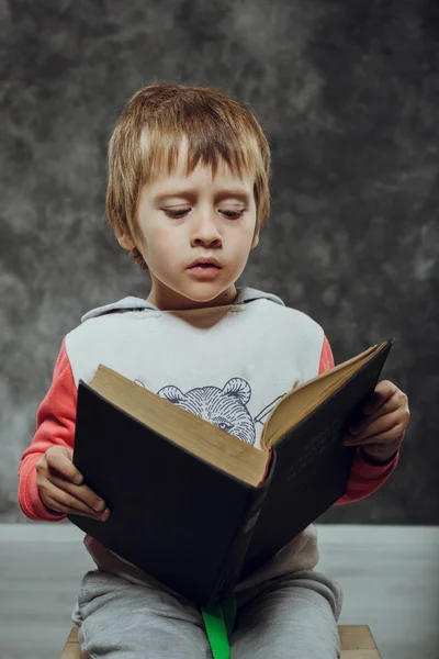 Jongen 5 jaar met boeken zittend op een stoel — Stockfoto