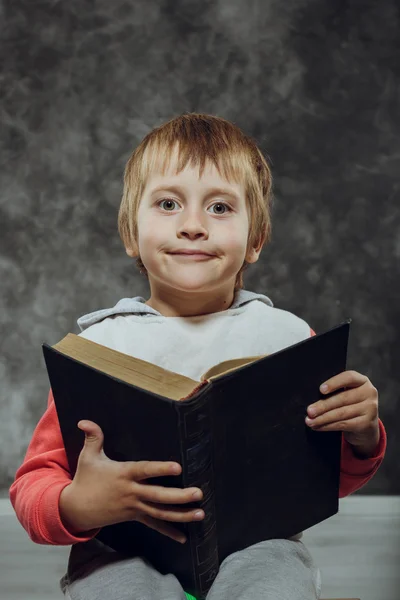 Menino 5 anos com livros sentados em uma cadeira — Fotografia de Stock