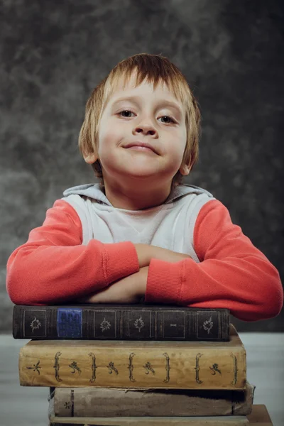 Αγόρι 5 ετών με βιβλία κάθεται σε μια καρέκλα — Φωτογραφία Αρχείου
