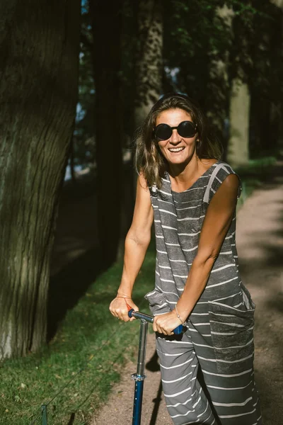 Hipster młoda kobieta na skuter w parku — Zdjęcie stockowe