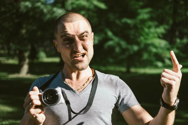 Злой фотограф с камерой в парке — стоковое фото