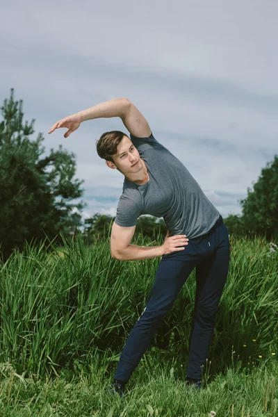 Erkek koşucu germe egzersiz yaparak sabah wor için hazırlanıyor