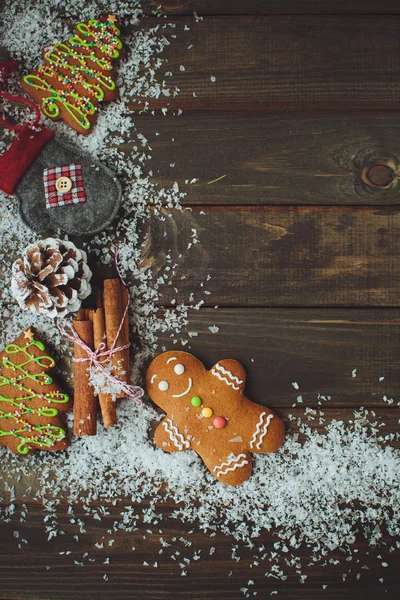 Fundo de madeira com homem de gengibre, cones, neve, vista superior, c — Fotografia de Stock