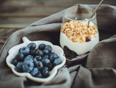 Granola ve taze yaban mersini, ol üzerinde cam kapta yoğurt