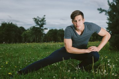 Erkek koşucu germe egzersiz yaparak sabah wor için hazırlanıyor