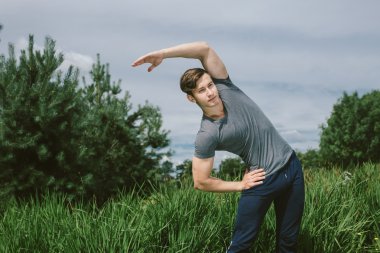 Erkek koşucu germe egzersiz yaparak sabah wor için hazırlanıyor