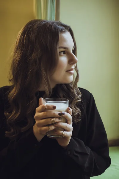 Mulher com xícara de café nas mãos no café — Fotografia de Stock