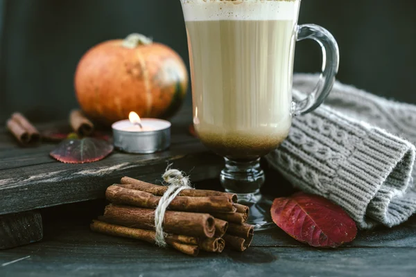 Spicy pumpkin latte on a wooden board with a sweater — Stock Photo, Image