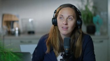 Evdeki dizüstü bilgisayarında mikrofon kaydı olan genç blogcu kadın. 