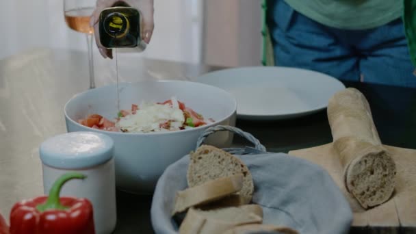 Mujer mano preparando ensalada fresca en casa. Familia cenando en la cocina — Vídeos de Stock