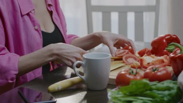 Kobieta przygotowuje świeżą sałatkę w domu. Rodzina je obiad w kuchni. — Wideo stockowe