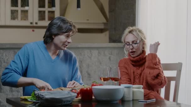 Heureux couple familial boire du vin et rire dans la cuisine. Mari et femme parlent célébrer vacances nouvelle maison — Video