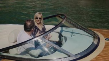 Mutlu yetişkin çift güzel manzaraya bakar ve gemi seyahatinde motorlu tekne ile eğlenir.