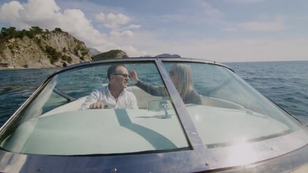 Романтична доросла пара цілує один одного і насолоджується круїзним моторним човном під час круїзу — стокове відео