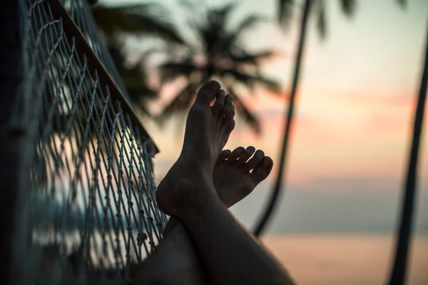 Beine in der Hängematte am Strand — Stockfoto