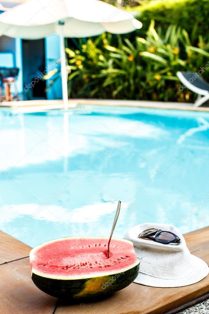 Watermelon and glasses near the pool