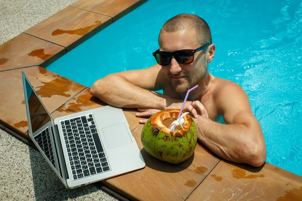 Ένας άνθρωπος με ένα φορητό υπολογιστή δίπλα στην πισίνα — Φωτογραφία Αρχείου