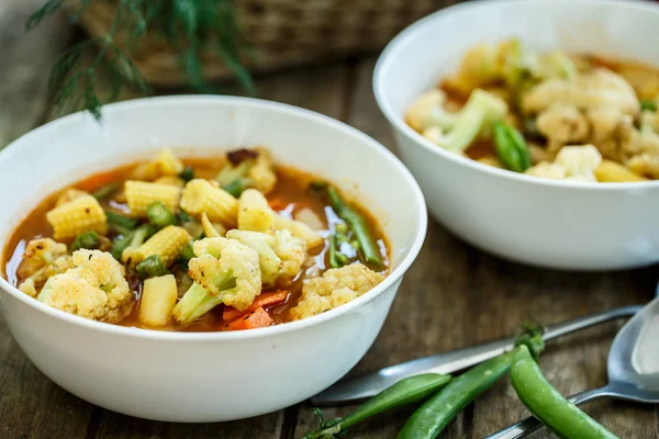 Legumes cozidos no vapor em uma tigela na mesa de madeira — Fotografia de Stock