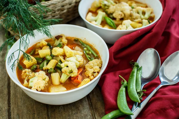 Steamed vegetables in a bowl on wooden table — Stock Photo, Image