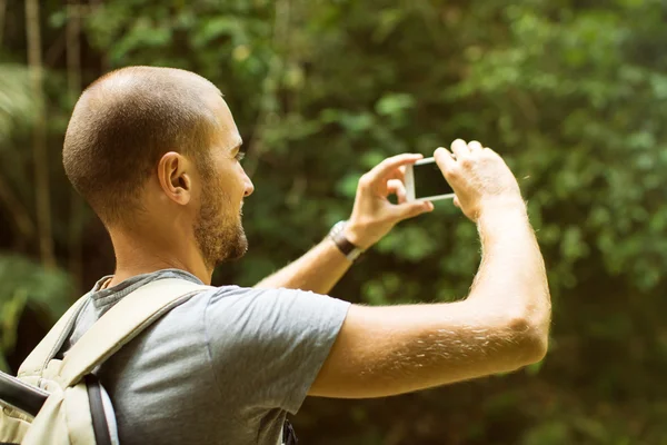 Пішохідний чоловік фотографує гірський пейзаж зі смартфоном . — стокове фото