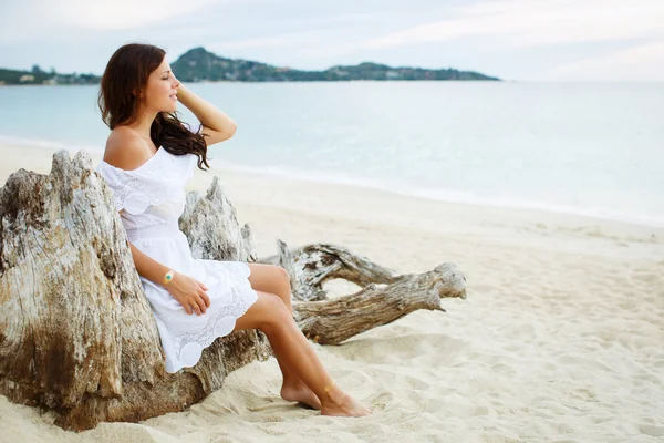 Relaxing beach woman enjoying the summer sun in white dress. Gla