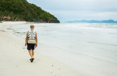 Genç Gezgin adamla yalnız deniz kenarında yürüyüş sırt çantası.