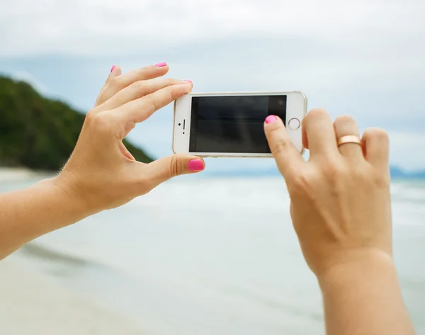 Woman hands showing a blank smart phone screen display on the be — Stock Photo, Image