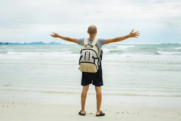 Fiatal utazó ember egyedül sétálni a tengerparton hátizsák. — Stock Fotó