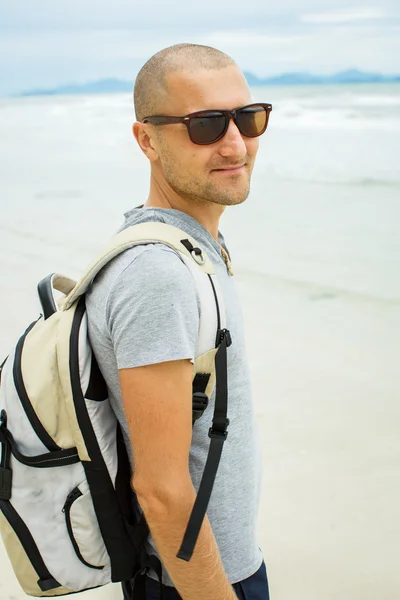 Молодой путешественник с рюкзаком идет один на море . — стоковое фото
